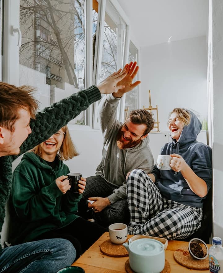 Four friends laughing over coffee